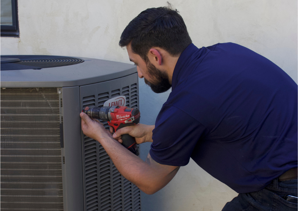 Professional HVAC technician examining outdoor AC unit