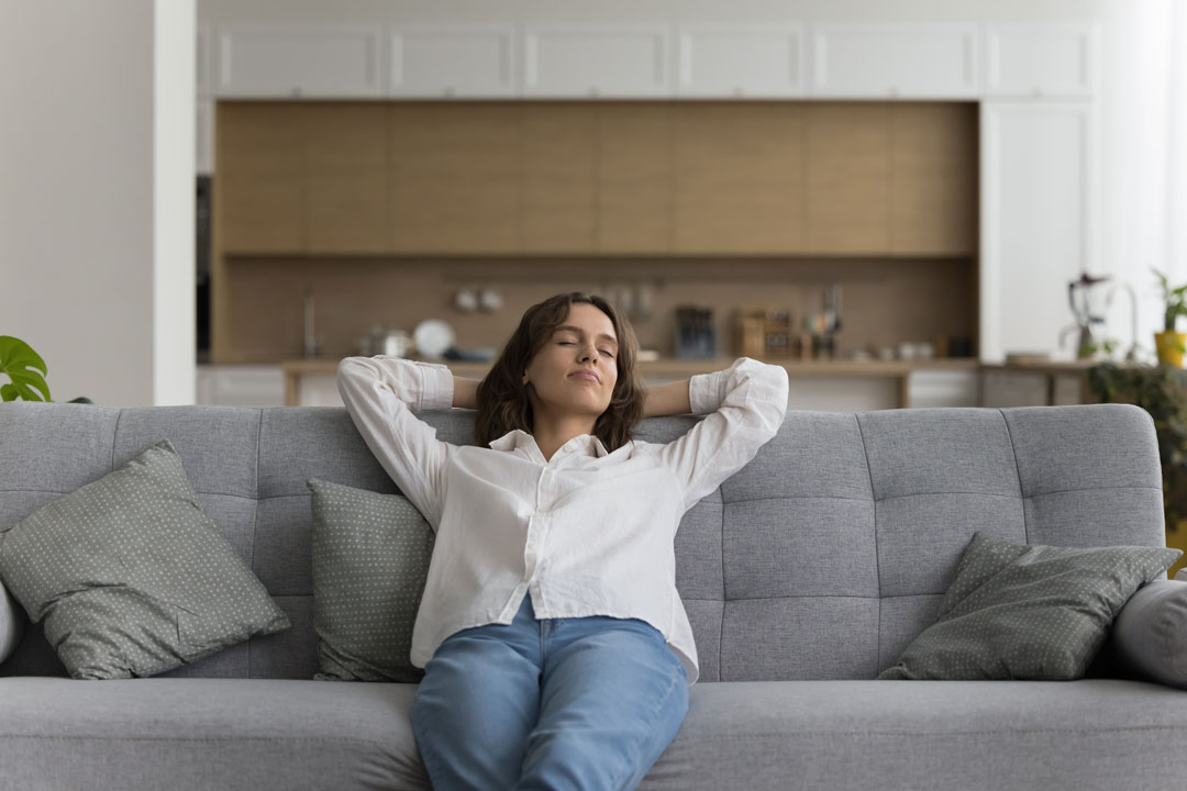 Peaceful Woman Relaxing On Sofa Inside Her Home